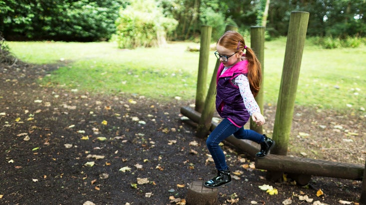 Child visitor in the natural play area at Springhill, County Londonderry, Northern Ireland